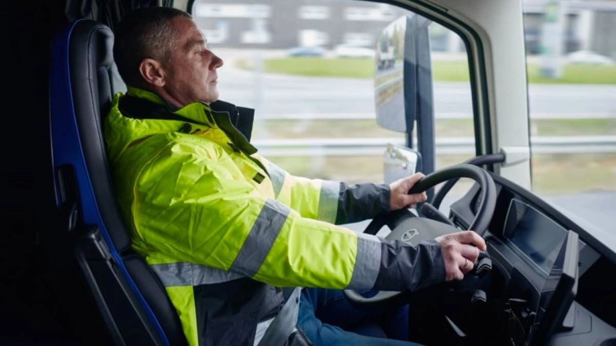 Sueldo de 3.200 euros y contrato indefinido: se necesitan 50 camioneros con urgencia Un conductor de camión con un chaleco amarillo conduce su vehículo.