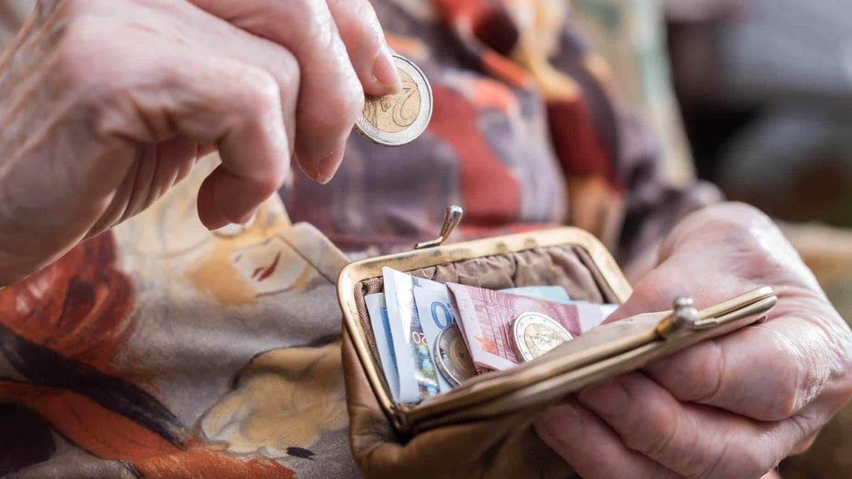 Señora mayor guardando dinero de euros en el monedero