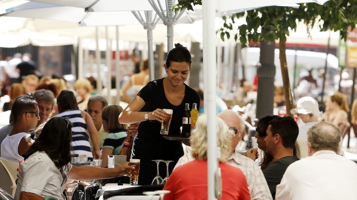 Se buscan camareros sin estudios: empleo fijo con opción de casa gratis y sueldo de 2.200 euros Una camarera sirve una mesa.