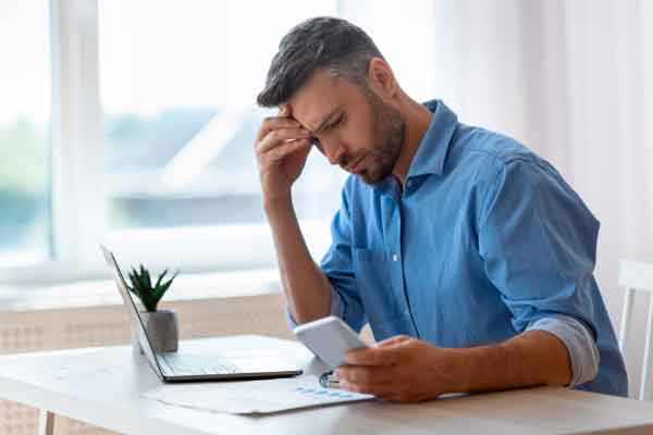 hombre observa en el móvil como ha sido estafado por internet