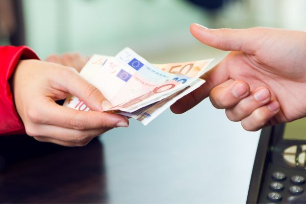 Personas realizando una operación con dinero en efectivo