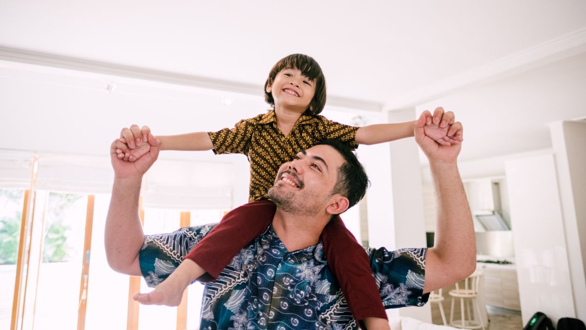 Padre con hijo a hombros.