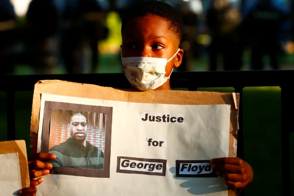 Chico pusa con una imagen de George Floyd